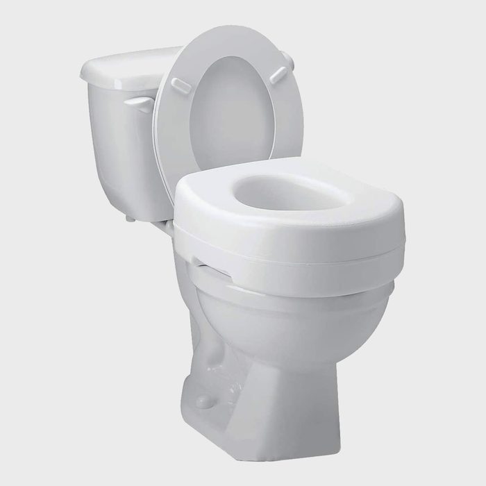 A white toilet is positioned upright with the lid raised, situated against a light background, designed for personal sanitation use.