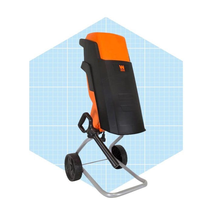 A garden tool with an orange and black body stands on a metallic frame with wheels, positioned against a light blue patterned background.