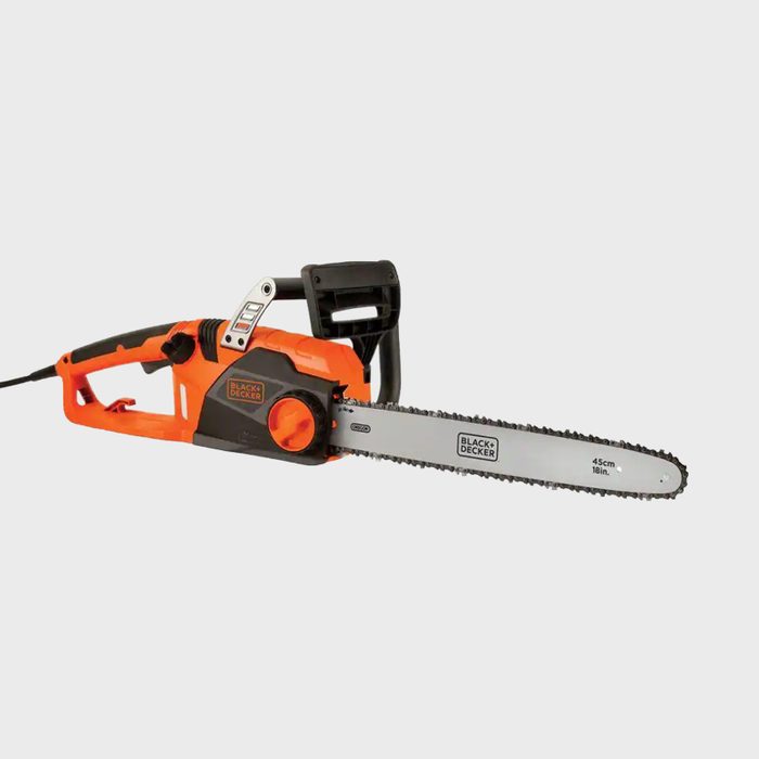 An electric chainsaw with an orange and black design sits stationary, featuring a long blade equipped for cutting through wood in outdoor settings.