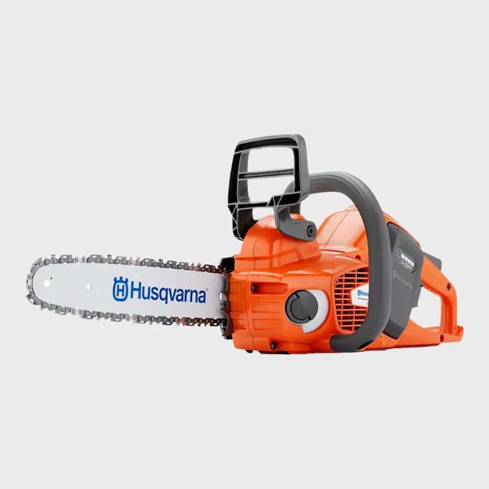 An orange chainsaw rests horizontally, featuring a metal blade with a logo. It
