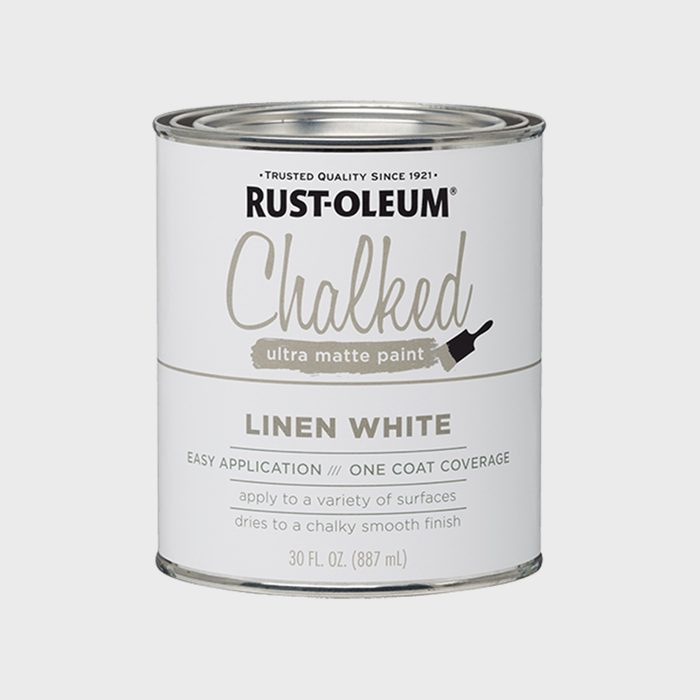 A cylindrical can of Rust-Oleum chalked ultra matte paint in linen white, labeled with application instructions and details, sits against a neutral background.