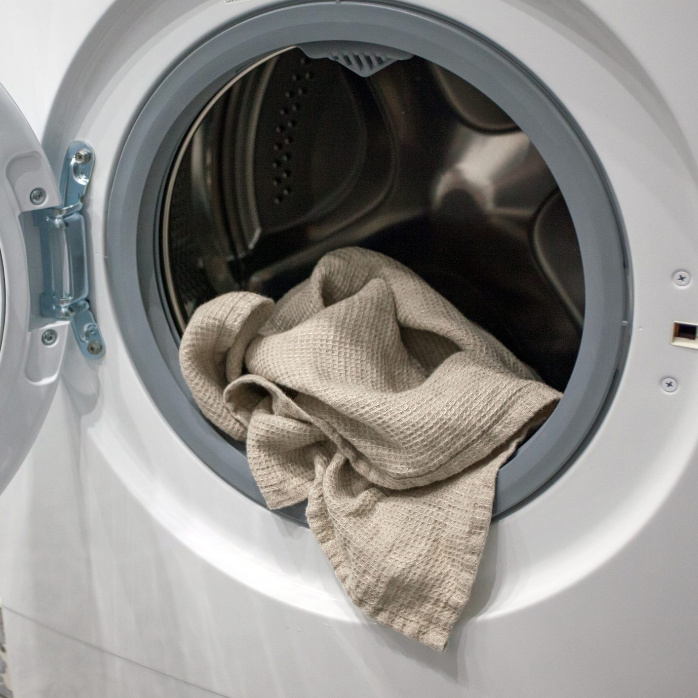 Towel hanging out of a washing machine