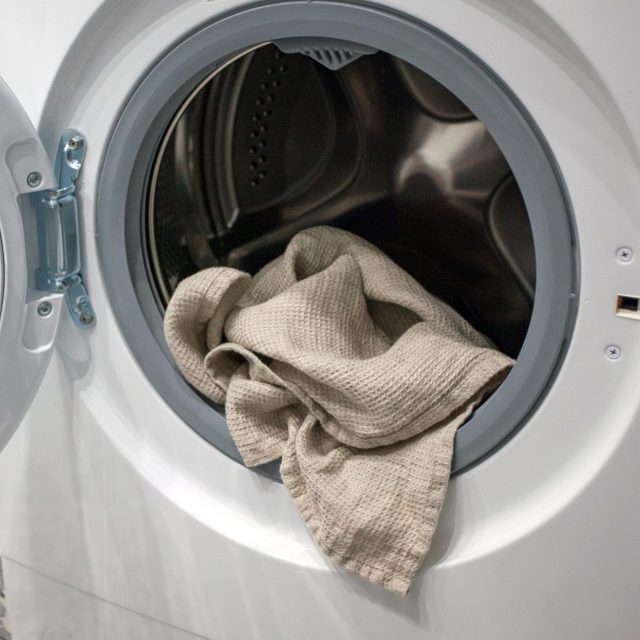 Towel hanging out of a washing machine