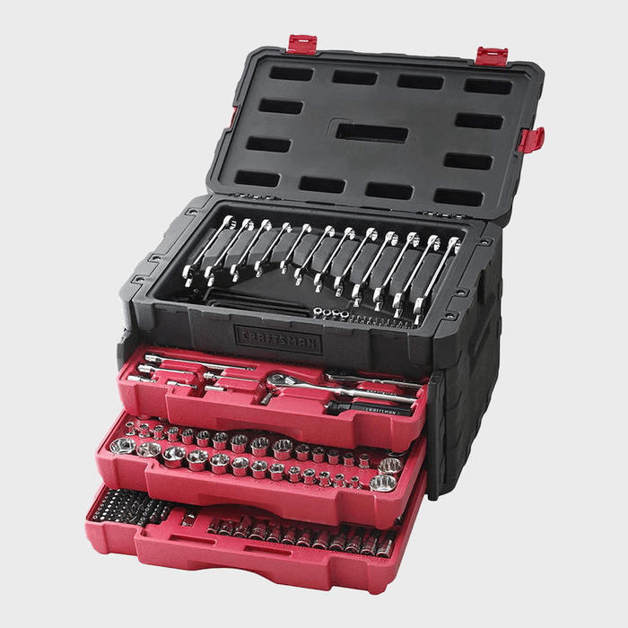 A black tool chest with red trays contains various socket wrenches and tools, positioned for easy access in a workshop or garage setting.