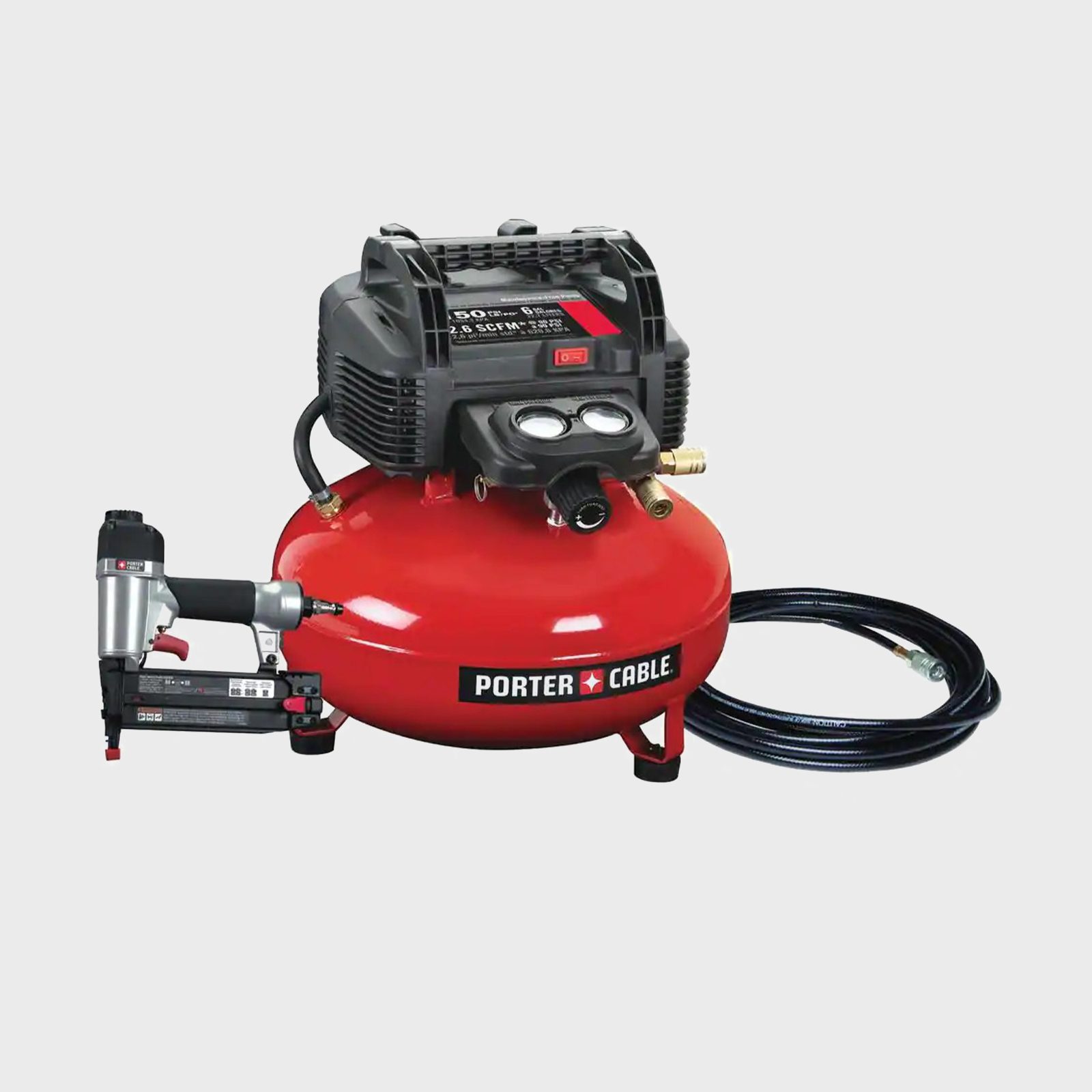 A red air compressor with a black motor powers a nail gun, connected by a hose for pneumatic applications, set against a neutral background.