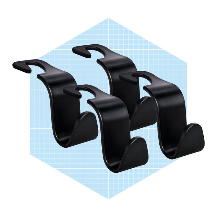 Four black hooks are neatly arranged, designed for hanging objects, set against a light blue grid background.
