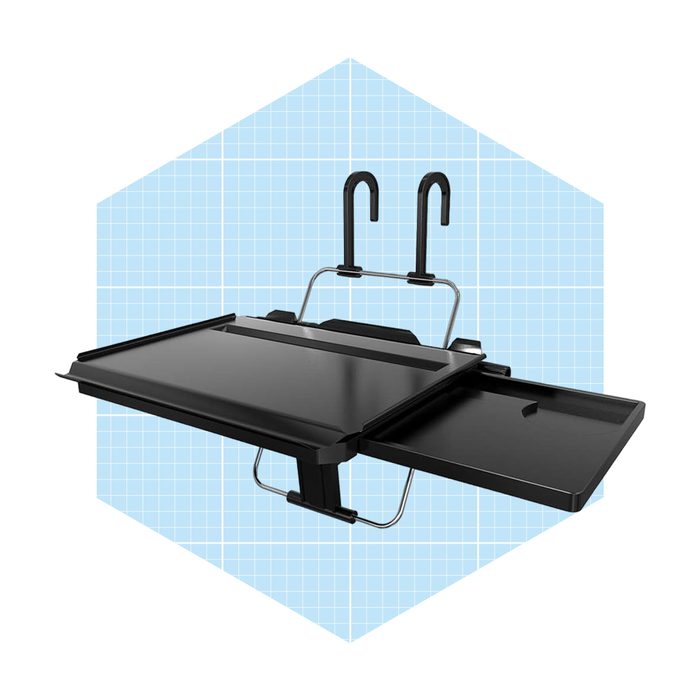 A black laptop tray with adjustable hooks is positioned against a light blue geometric background, providing a stable surface for work or tasks.