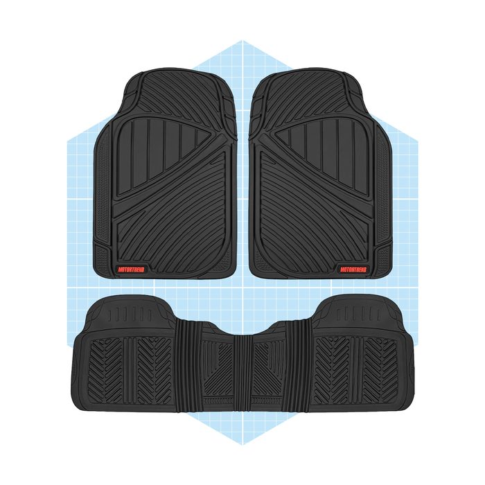 Four black rubber floor mats are arranged symmetrically on a light blue grid background, designed for vehicle use with textured patterns for grip.