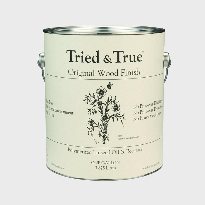 A metal paint can labeled "Tried & True Original Wood Finish" displays floral artwork, contains polymerized linseed oil and beeswax, and states it