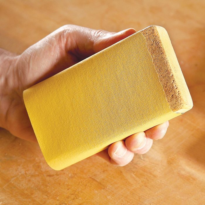 hand holding a sanding block
