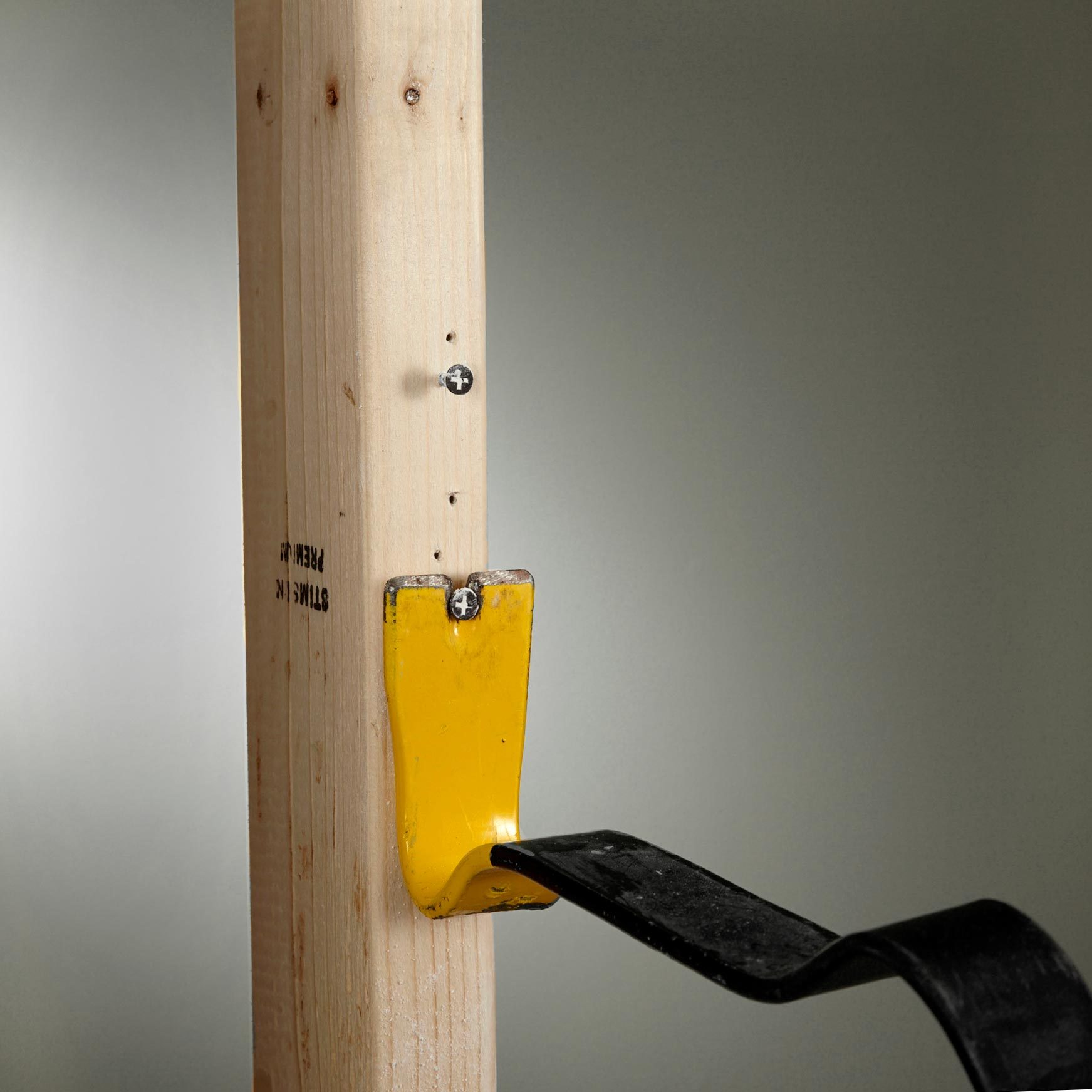 pulling drywall screws from a piece of wood with a pry bar