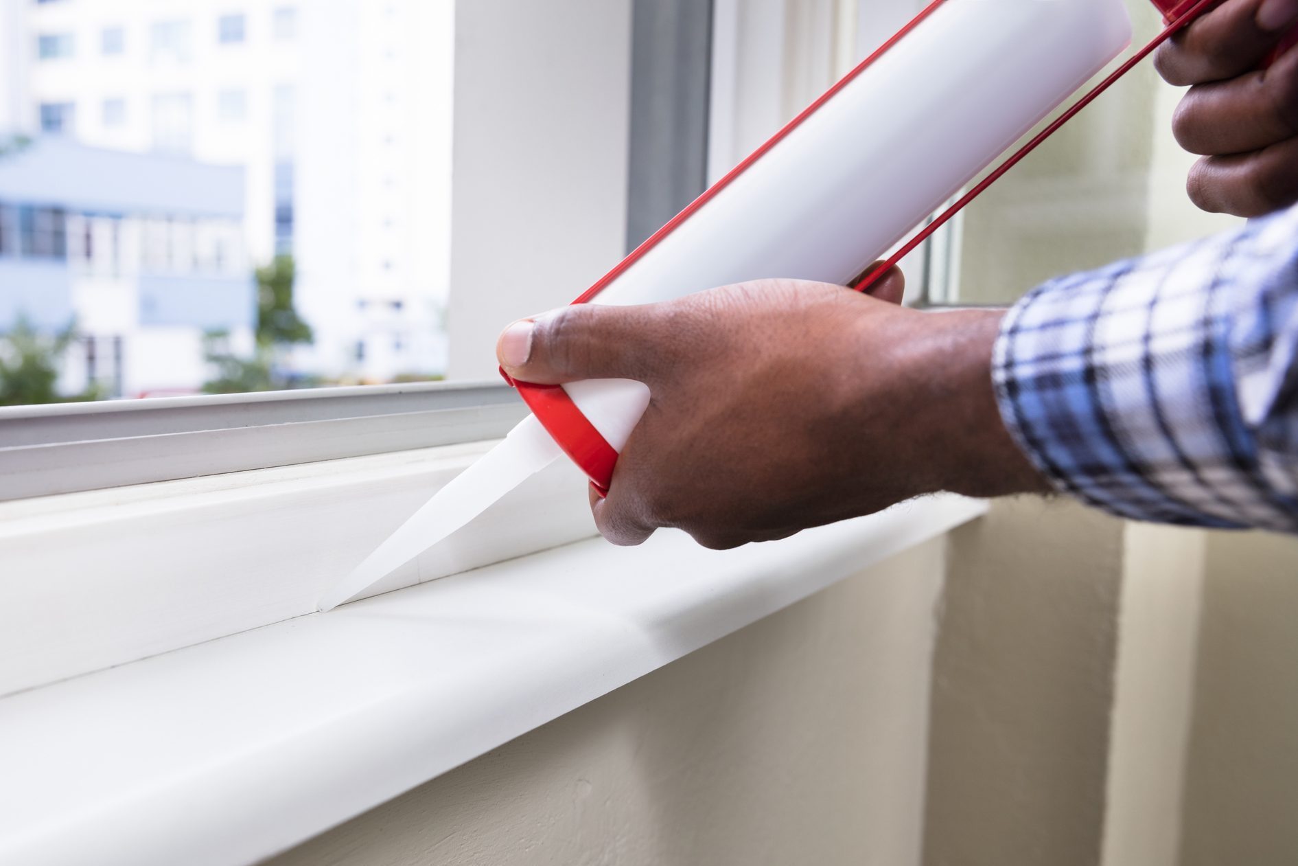 Person Hand Applying chemical Sealant With Silicone Gun