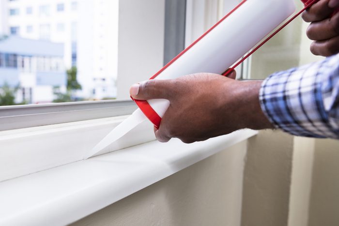 Person Hand Applying chemical Sealant With Silicone Gun