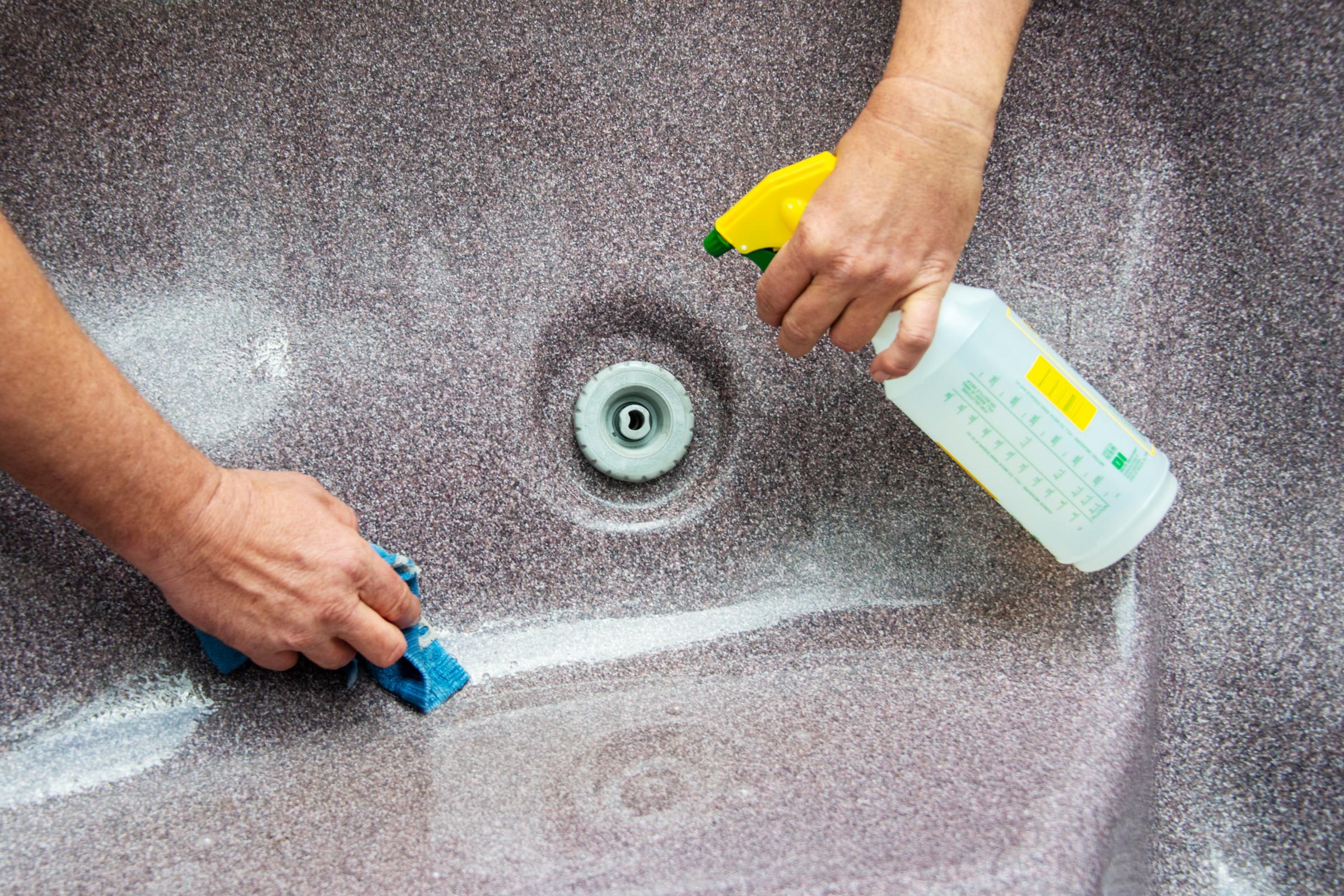 cleaning the hot tub with spray cleaner and a rag