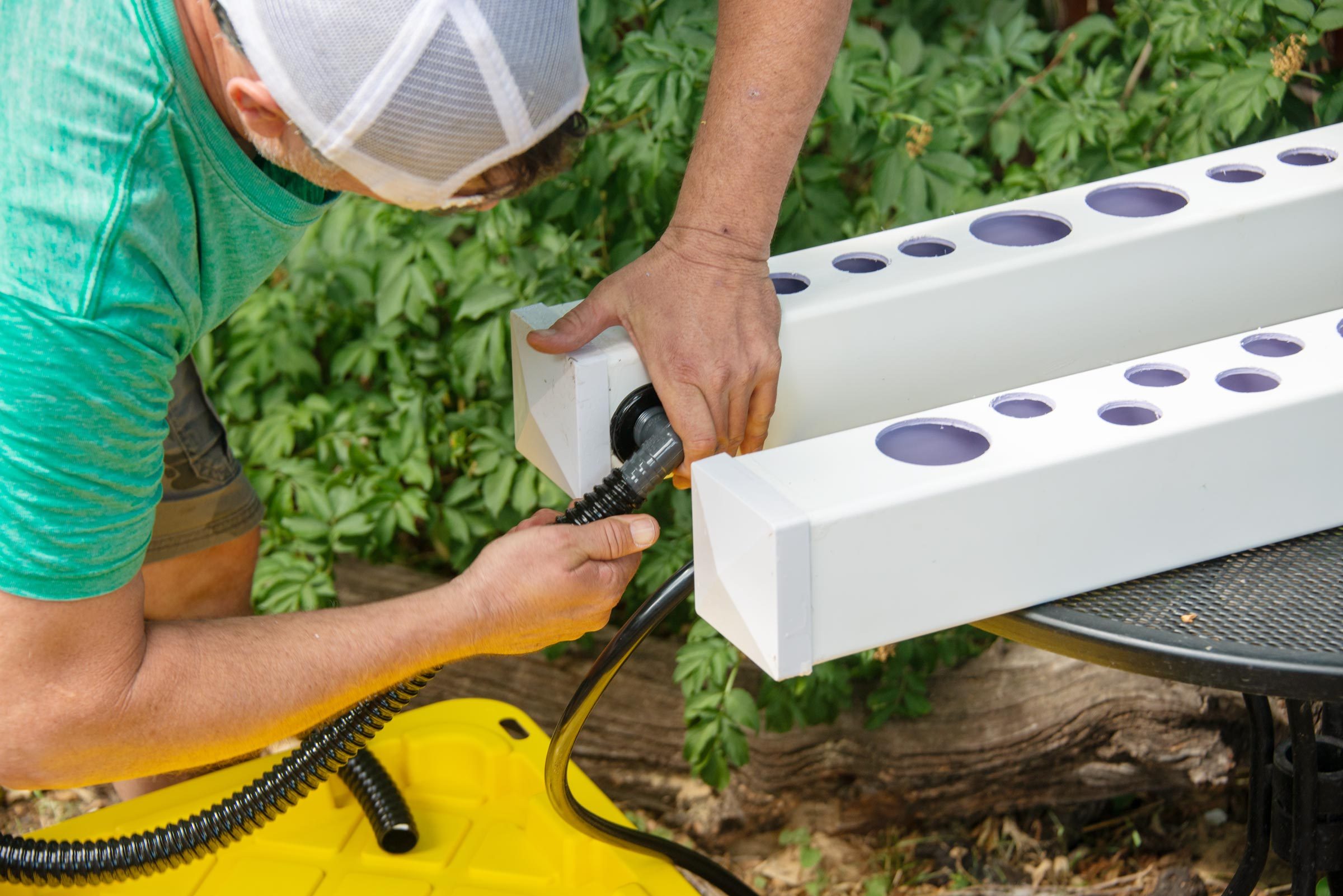 a man connecting the tubing to the elbow on the side of the rail