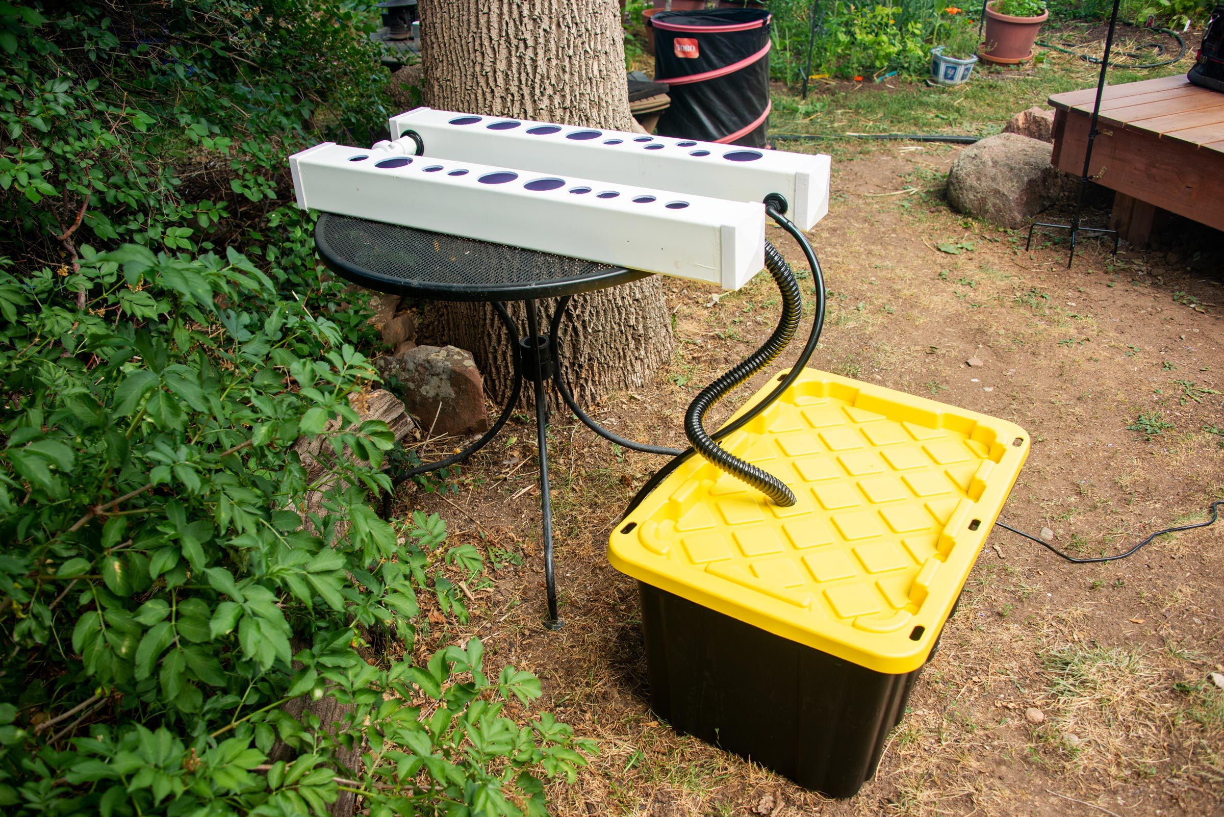 the rails and the plastic bin reservoir connected together with a black corrugated hose