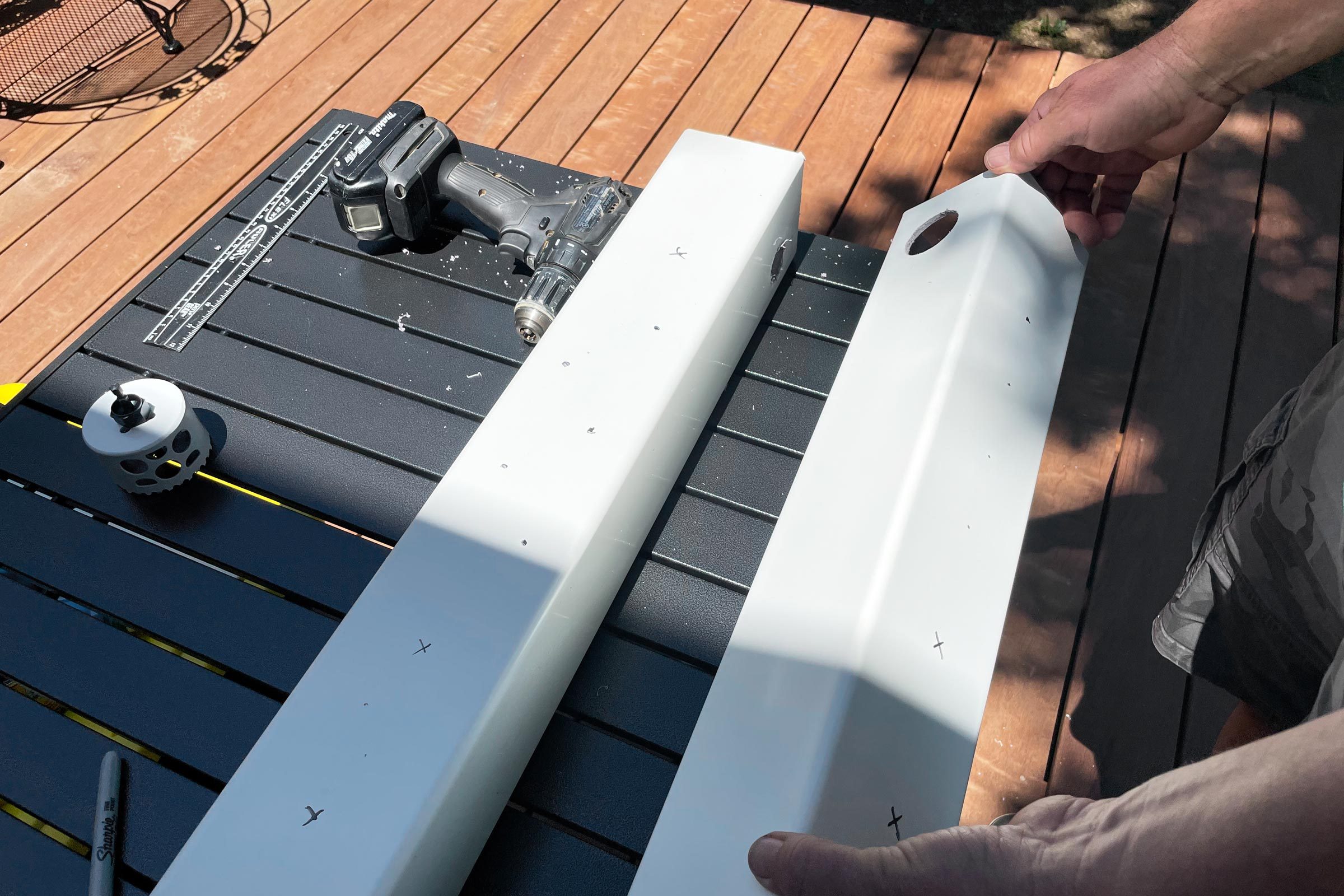  two rails on a black outdoor table with holes drilled