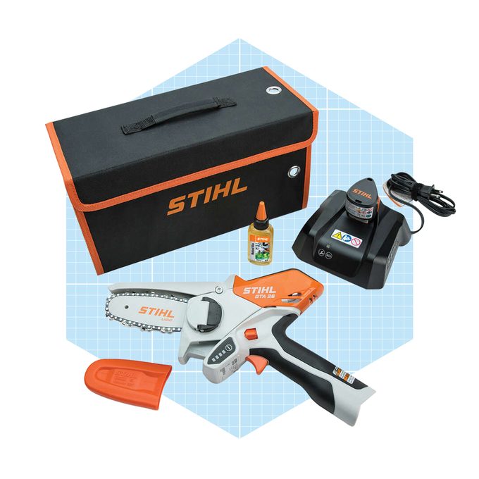 A compact electric chainsaw and accessories are arranged neatly, including a charging station, oil, and a protective case, set against a light geometric background.