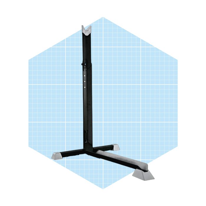 A black, adjustable stand with a triangular base supports a vertical pole, set against a light blue grid-patterned background.