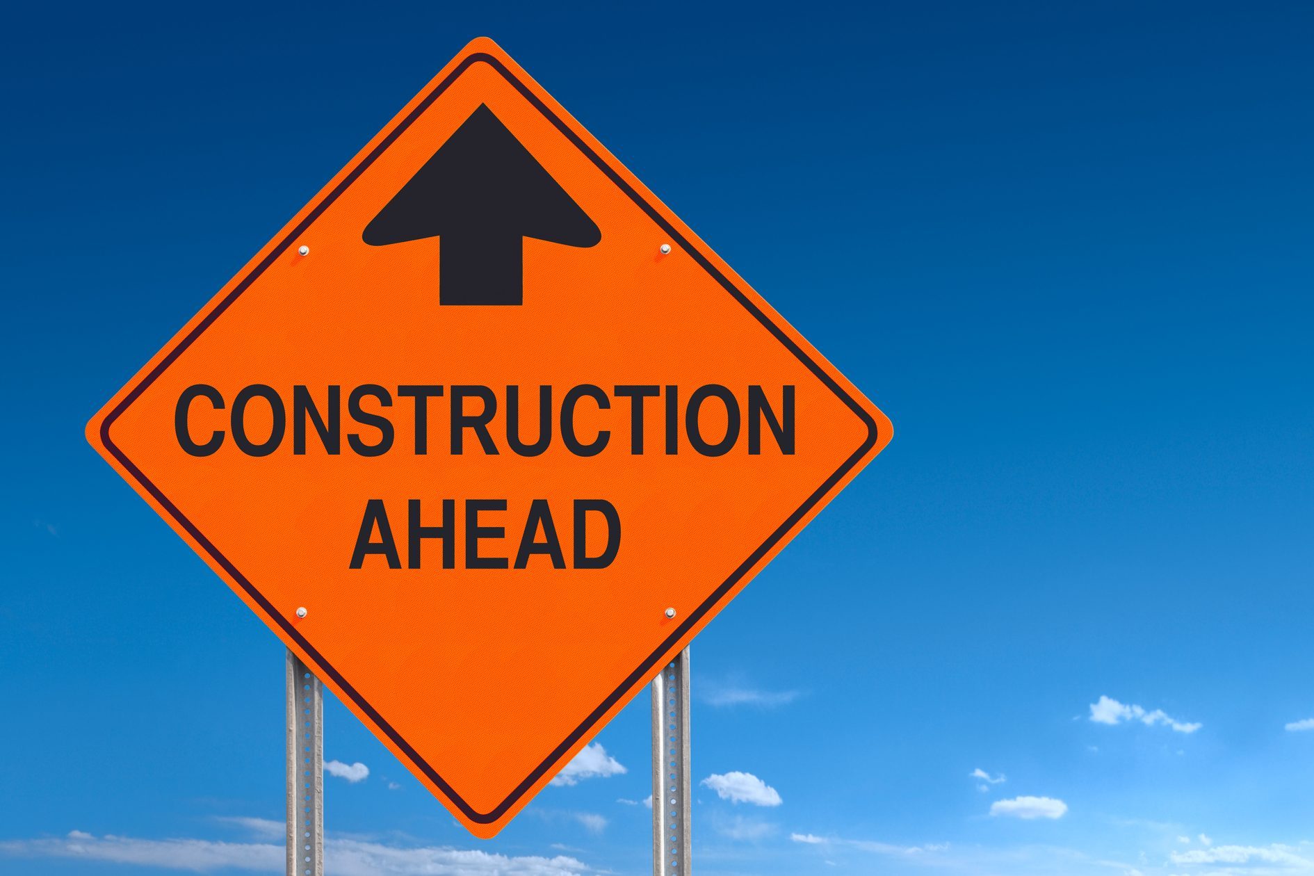 Orange Warning Construction Ahead Message Road Sign Over Blue Sky