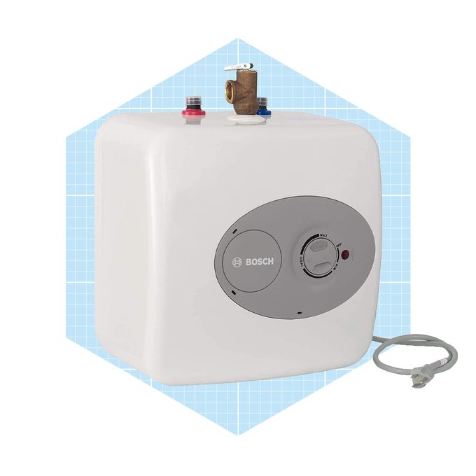 A white water heater is mounted, featuring control knobs and inlet connections, set against a light blue grid background.