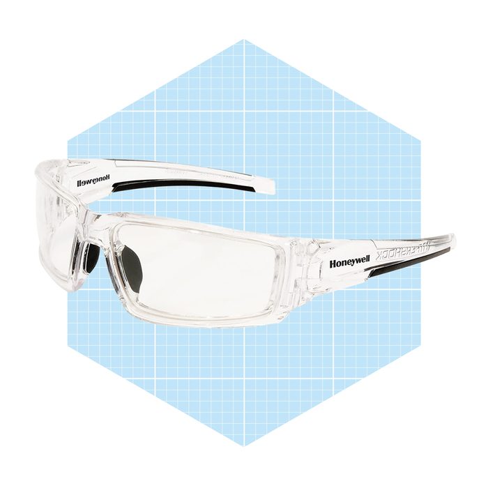 Clear safety glasses are displayed, highlighting their design and brand label. The background features a light blue grid, suggesting a product showcase.