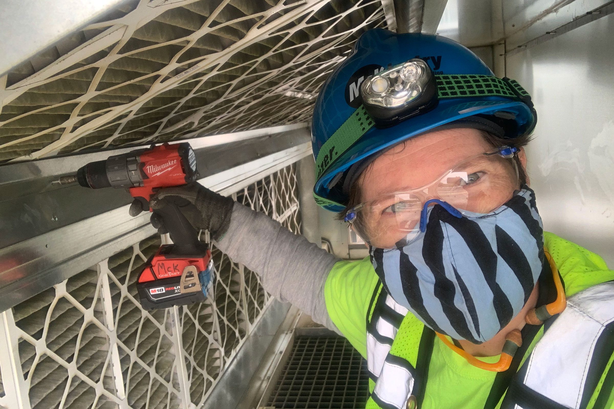 Soph Davenberry holding a drill and wearing a hard hat while working