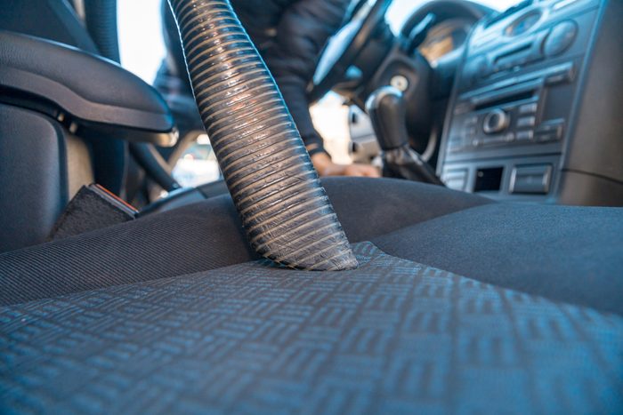 vehicle interior vacuum cleaning. Detail shot of an industrial vacuum cleaner cleaning a car seat