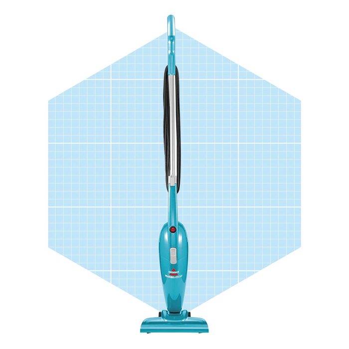 A teal upright vacuum cleaner stands upright, featuring a power button and a sleek design, set against a light blue grid background.