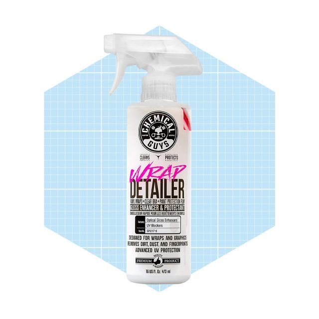 A spray bottle labeled "Wrap Detailer" enhances and protects vehicle wraps, displayed against a light blue grid background, indicating cleaning product use.