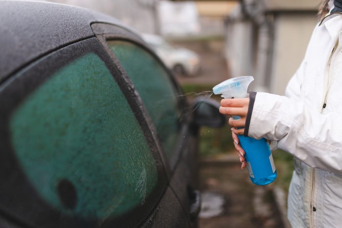 Close-up of a defrost spray used on a car window