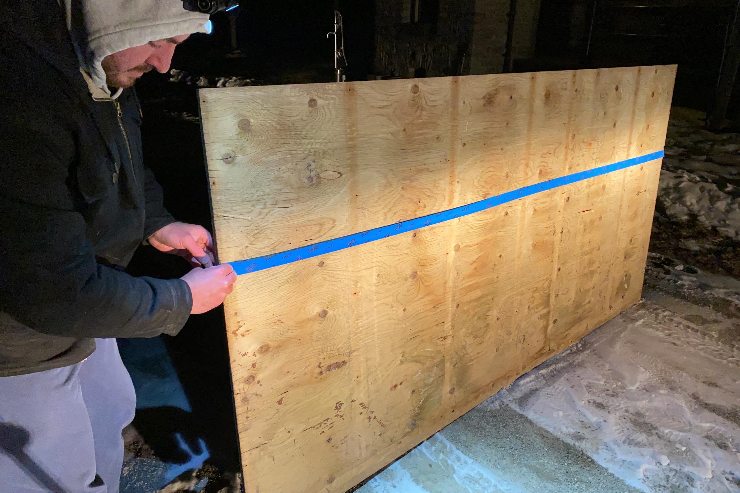 adding a piece of painters tape across a piece of plywood