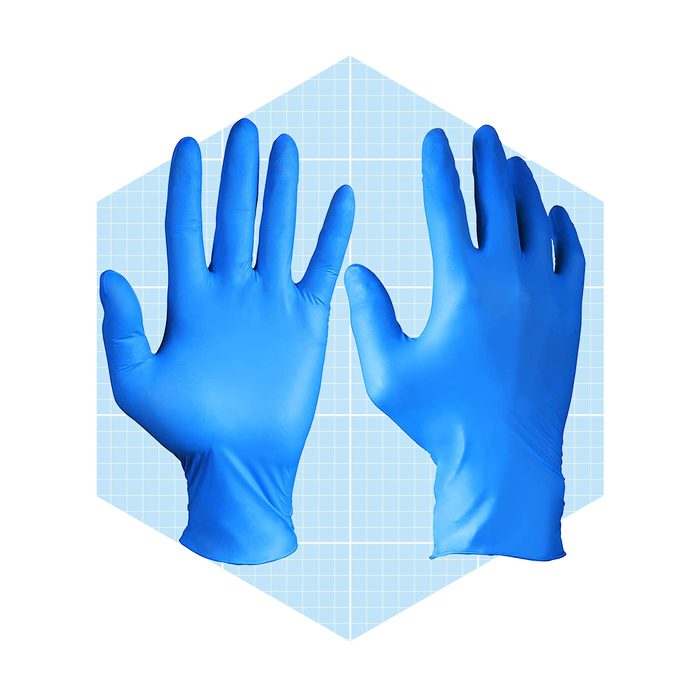 Two blue latex gloves are positioned upright, showcasing their shape and texture against a light blue grid background. They are ready for use in hygiene-related tasks.