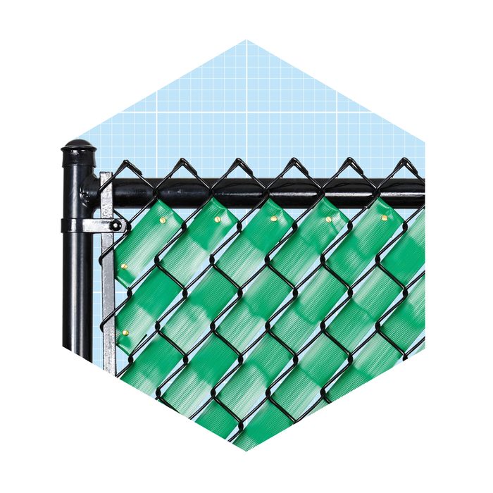 A black chain link fence with a green windscreen is standing upright against a light blue grid background.