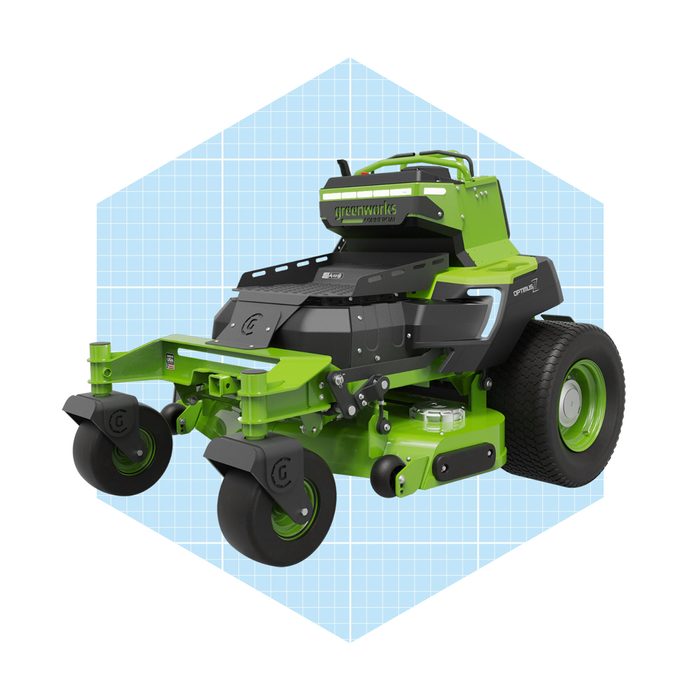 A green and black lawn mower sits prominently, showcasing its wheels and design against a light blue grid background.