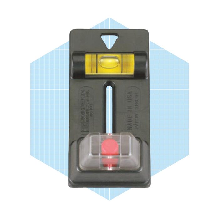 A level tool sits on a blue geometric background, featuring a horizontal bubble vial and a red plumb indicator for precise alignment measurement.