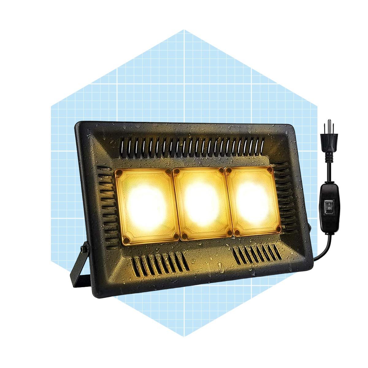 A rectangular floodlight with three bright bulbs is positioned vertically, connected to a power cord with a switch, set against a light blue grid background.