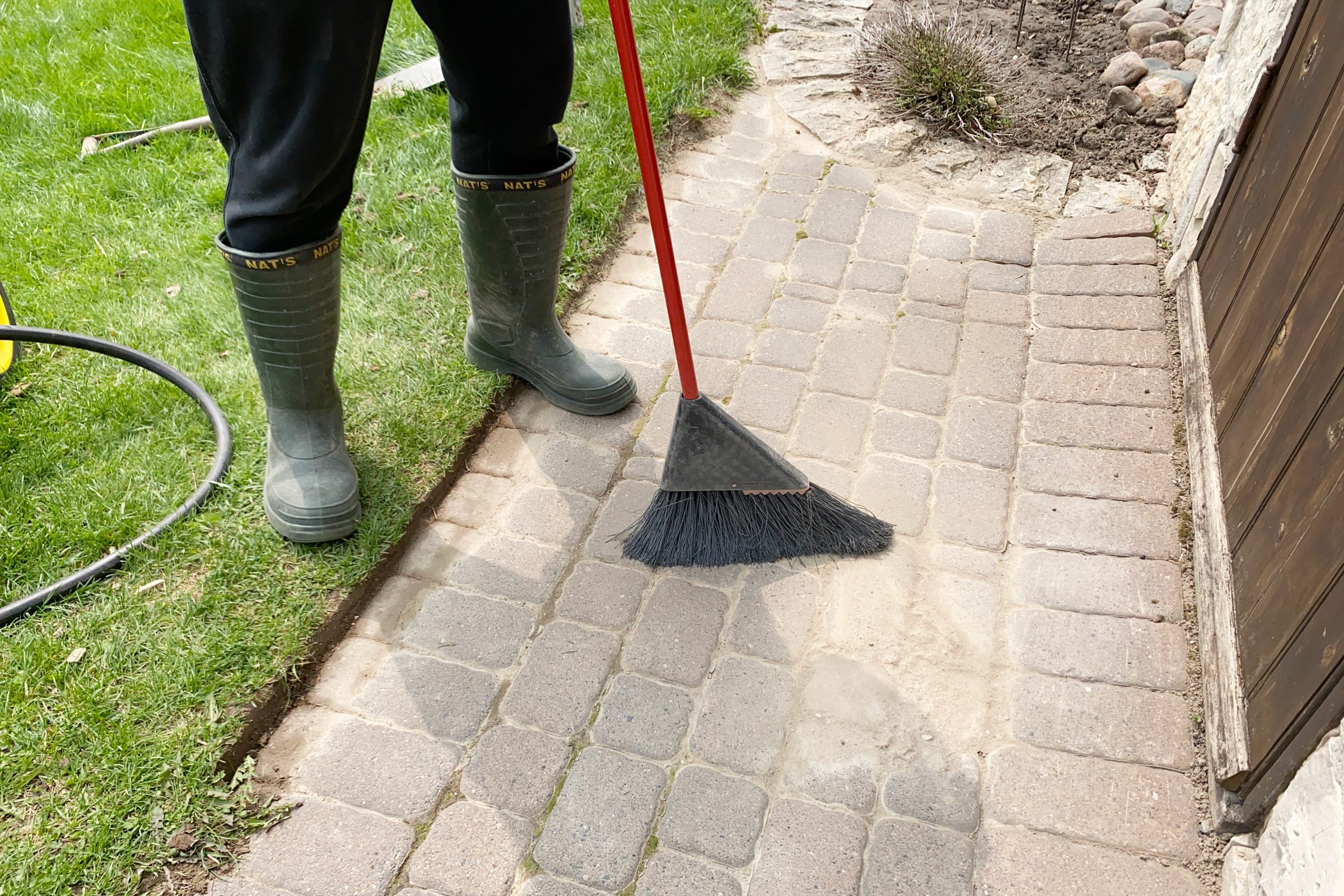 sweeping a sidewalk of pavers