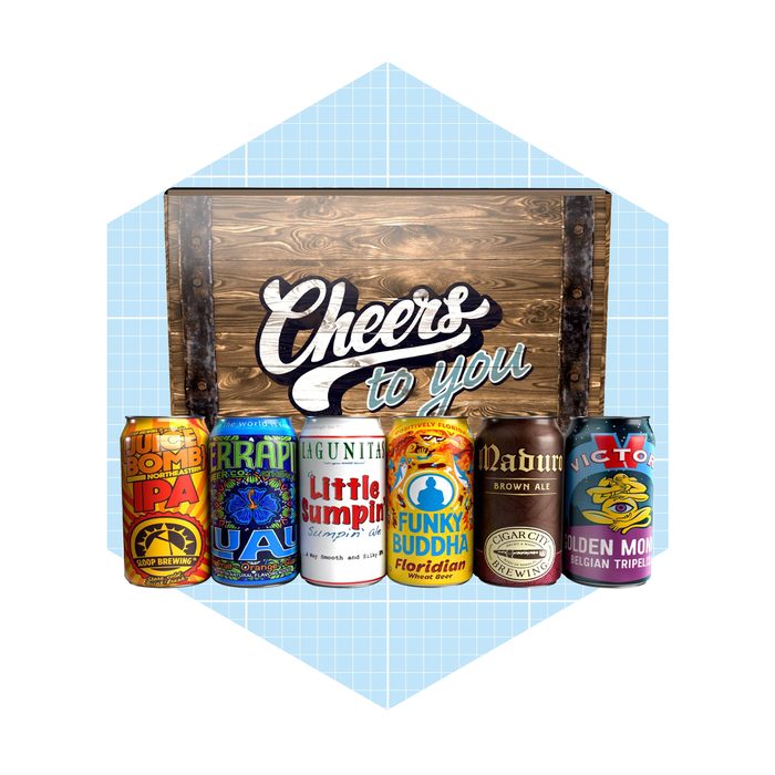 Seven colorful beer cans are arranged in front of a wooden sign that reads, 