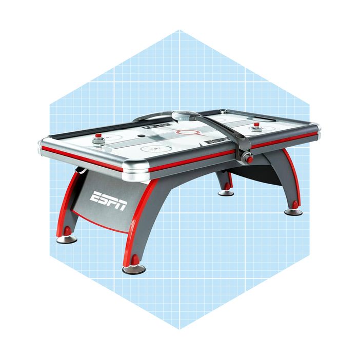 A modern air hockey table features a sleek design with an ESPN logo, positioned against a light blue grid background, ready for play.