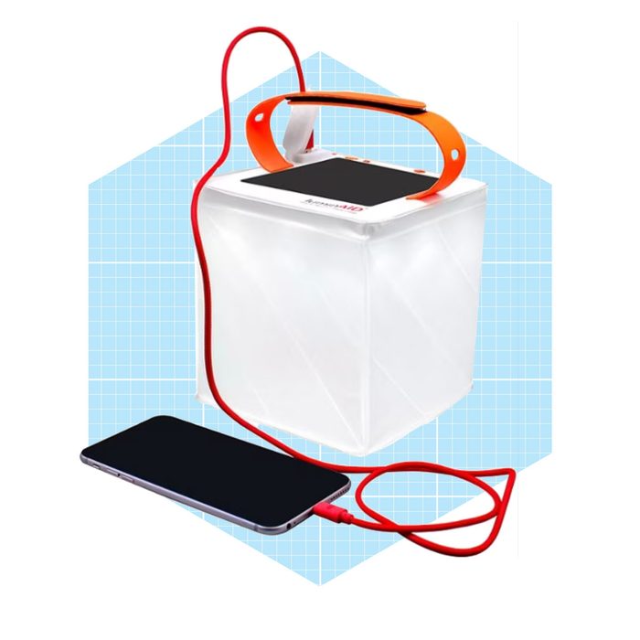 A portable solar charger powers a smartphone through a red cord, situated against a light blue grid background.