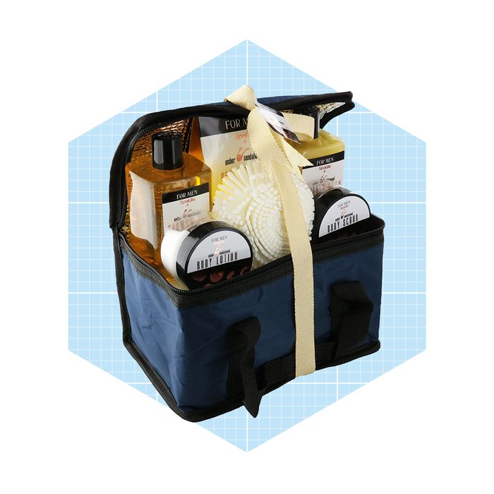 A navy blue bag contains various grooming products, including body lotion and scrubs, displayed against a light blue grid background.