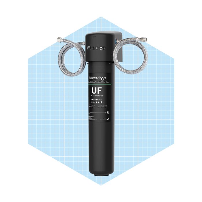 A cylindrical black water filter is connected to two metal hoses, designed for efficient filtration, set against a light blue grid background.