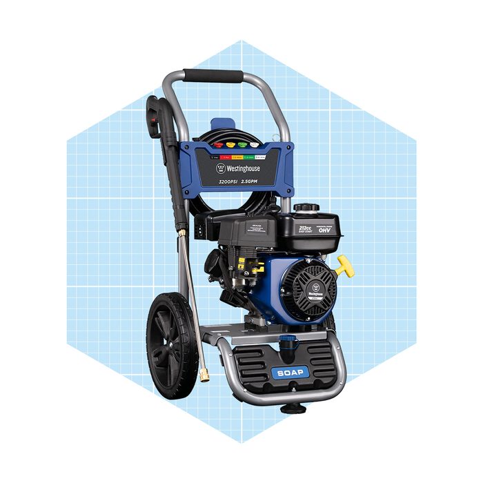 A blue power washer stands upright, ready for use, featuring a large handle, control panel, and wheels, set against a geometric light blue background.