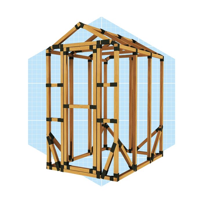 A wooden frame structure stands upright, showcasing its supporting beams and cross bracing, set against a light blue grid background.