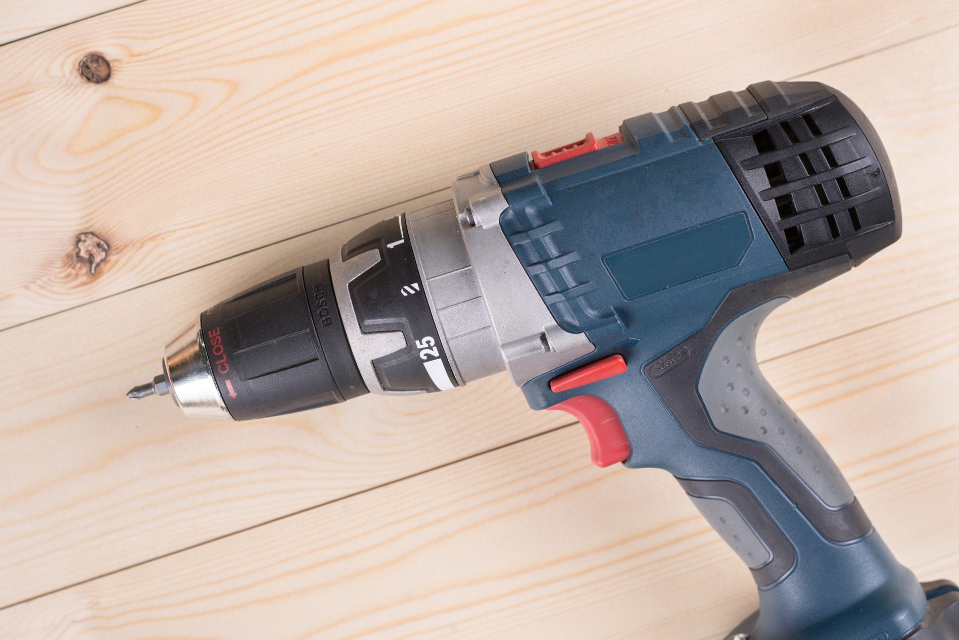 Flat lay cordless drill on the wooden boards with copy space