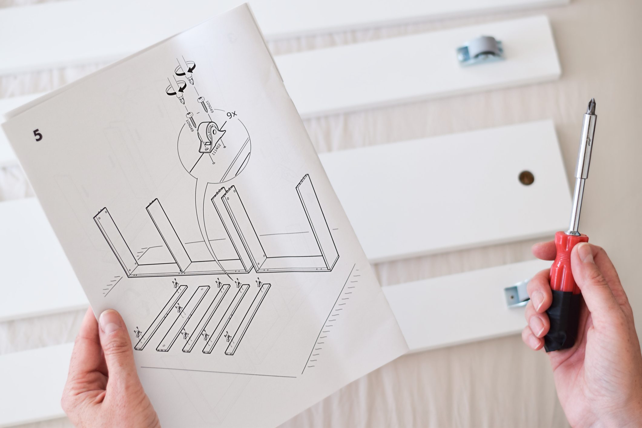Woman reading an instruction manual to assemble furniture