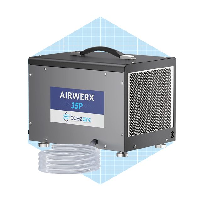 A compact air filtration unit operates, featuring a handle and a vented side, placed next to a clear flexible hose on a light blue background.