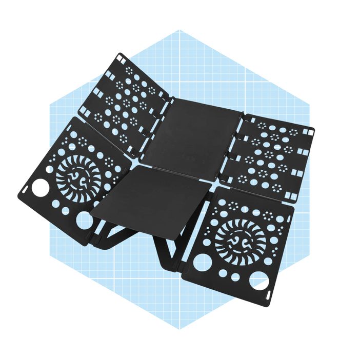 A black multi-panel tool lies open, displaying intricate cut-out designs, set against a light blue grid background, suggesting a design or crafting context.