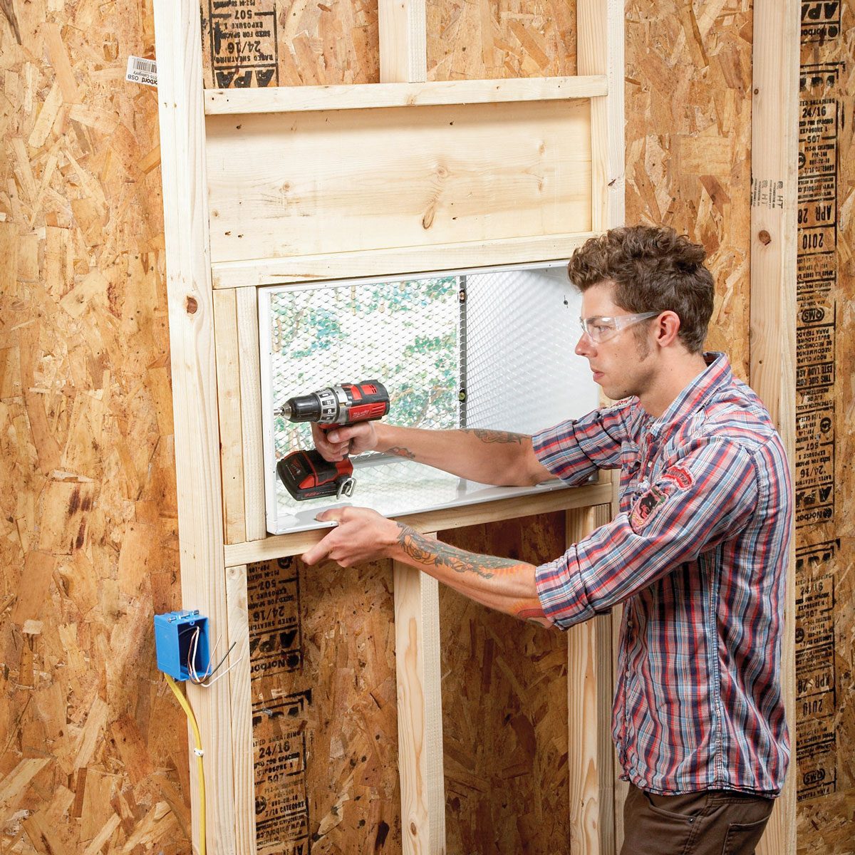 A Man Fixing Through The Wall AC in Garage with Drill